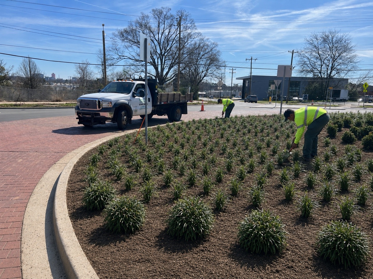 Roundtree crew completing a commercial landscape installation with company truck on site