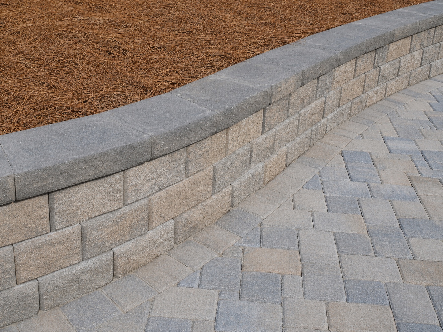 Segmental retaining wall detail with paver surface and finished cap stones.