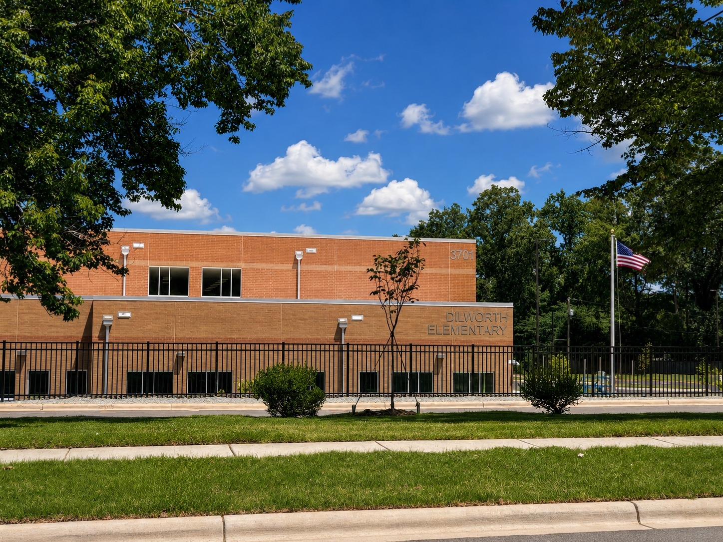 Finished school landscape with established turf, newly installed tree and foundation planting.