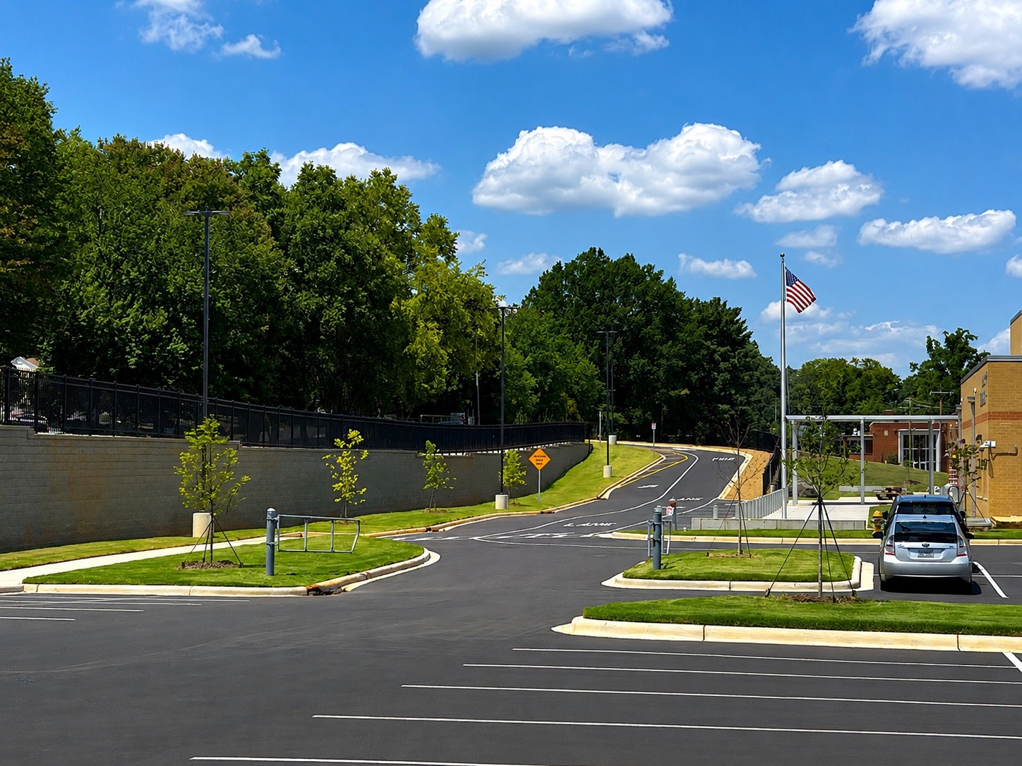 Completed school site landscaping with established turf, new trees and finished drive aisles.