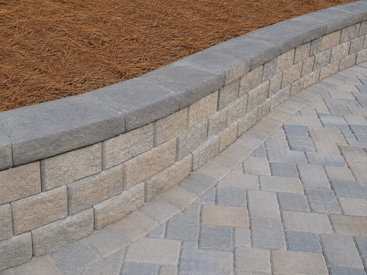 Segmental retaining wall detail with paver surface and finished cap stones.