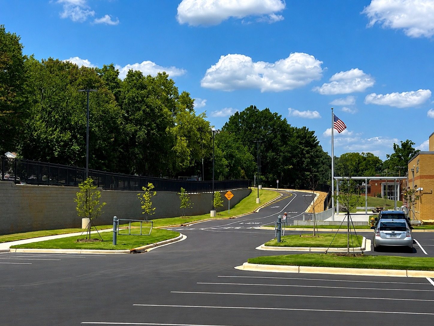 Completed school site landscaping with established turf, new trees and finished drive aisles.